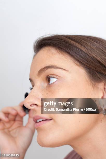 side view headshot of woman applying mascara - showus makeup stock pictures, royalty-free photos & images