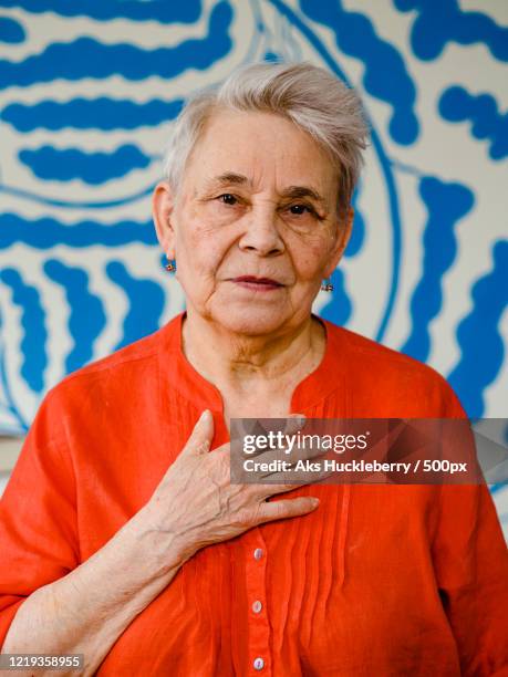 portrait of elderly woman - main sur la poitrine photos et images de collection