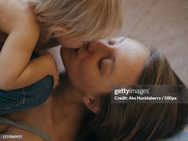 young woman kissing her baby girl, russia - usar la boca fotografías e imágenes de stock