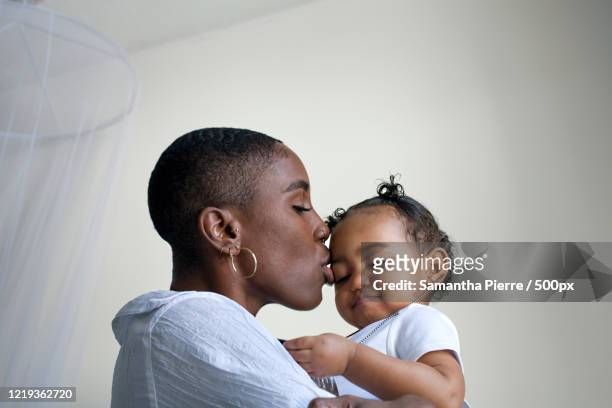 close up portrait of young mother holding baby daughter - showus stock-fotos und bilder
