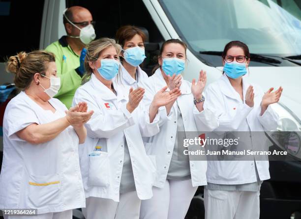 Health workers wearing protective gear applaud during a flash mob at the Marques de Valdecilla Hospital on April 16, 2020 in Santander, Spain. Spain...