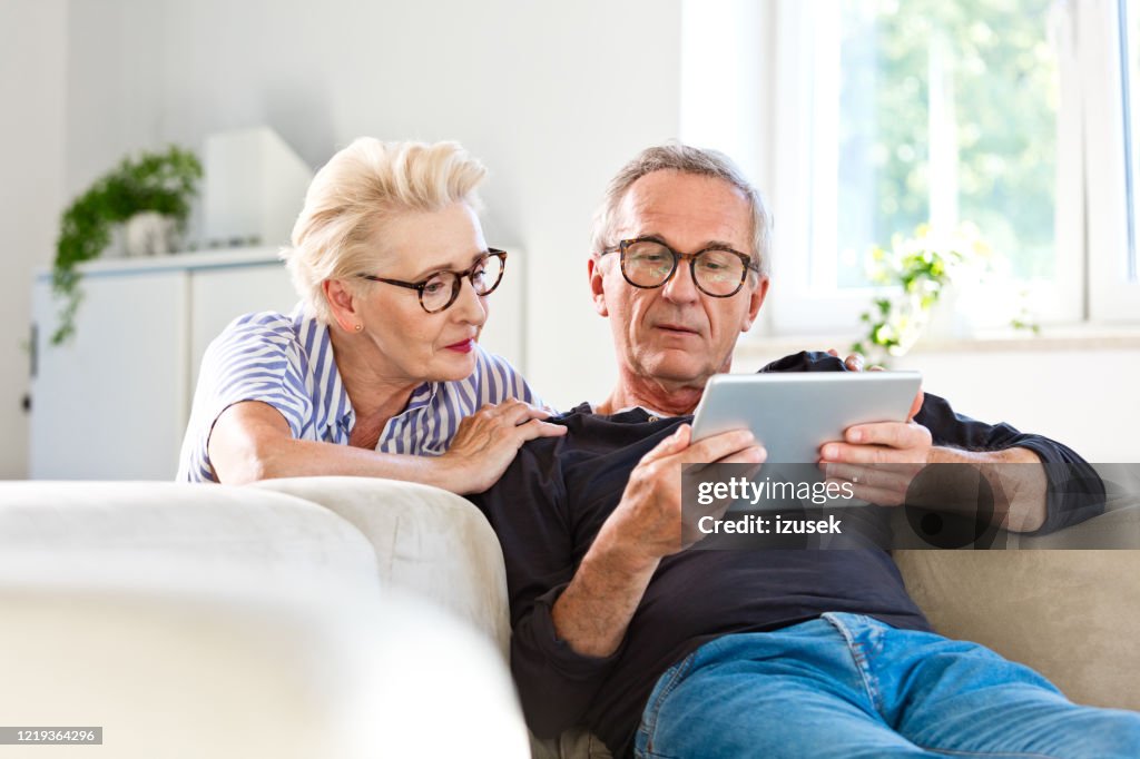 Senior-Paar schaut digitales Tablet zusammen zu Hause