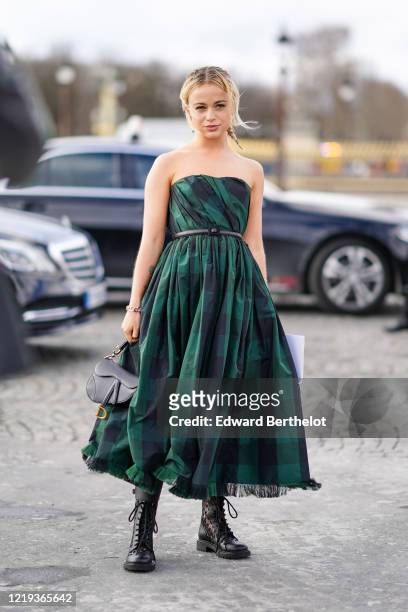 Lady Amelia Windsor wears an off-shoulders green pleated checked dress, a Dior black leather Saddle bag, boots, outside Dior, during Paris Fashion...