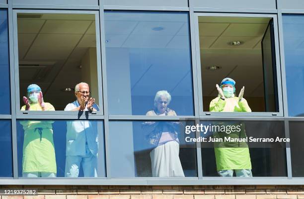 Health workers wearing protective gear applaud during a flash mob at the Elderly Homes on April 17, 2020 in Santander, Spain. Spain is beginning to...