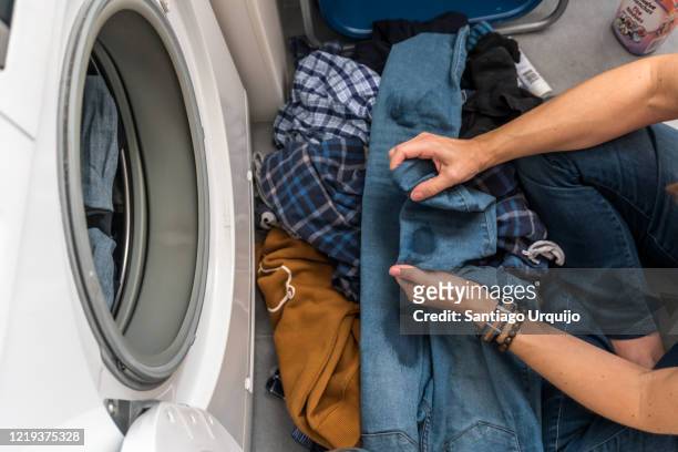 woman adding stain remover to clothes before washing them - stained stock pictures, royalty-free photos & images