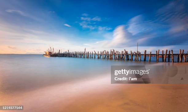 old jetty at black sand beach in langkawi island, malaysia. - langkawi stock-fotos und bilder