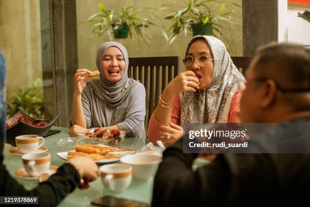 happy asian friends having iftar together - indonesia family stock pictures, royalty-free photos & images