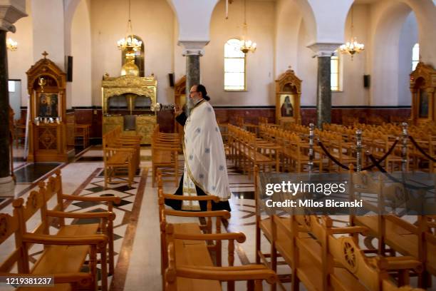 Greek Orthodox priests perform Holy Friday ceremony mass in empty church, transmitted live on the web on April 17, 2020 in Athens, Greece. As part of...