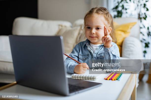 little girl taking online courses in living room - remote location stock pictures, royalty-free photos & images