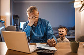 Stressed Man With his two years old son Working From Home