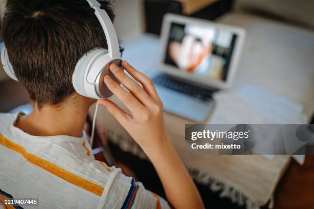 teenage boy learning to play guitar watching online tutorial - tuition stock pictures, royalty-free photos & images