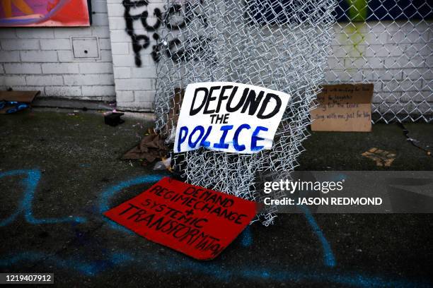 Protest signs and graffiti are pictured outside the closed Seattle Police Department's East Precinct now surrounded by the area known as the Capitol...