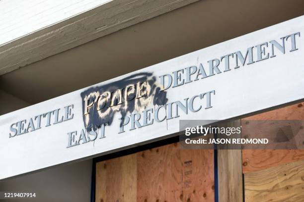 The word "people" is spray painted over the word "police" on the closed Seattle Police Department's East Precinct now surrounded by the area known as...