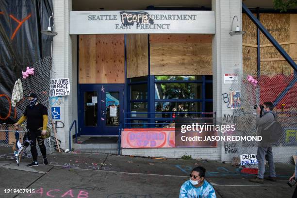 The word "people" is spray painted over the word "police" on the closed Seattle Police Department's East Precinct now surrounded by the area known as...