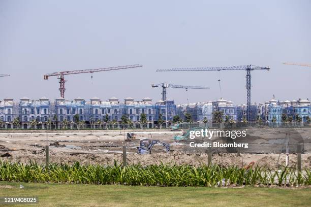 Excavators operate on ground near a row of under construction houses at VinCity Ocean Park, operated by Vingroup JSC, in Hanoi, Vietnam, on...