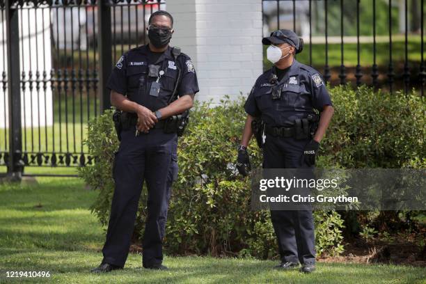 Members of the police stand by as protestors gather outside the Louisiana State Governor's mansion during a rally against Louisiana's stay-at-home...