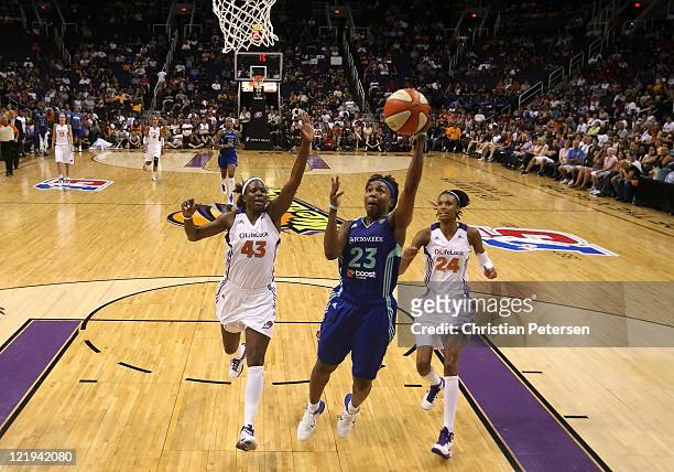 Cappie Pondexter of the New York Liberty lays up a shot past Nakia Sanford and DeWanna Bonner of the Phoenix Mercury during the WNBA game at US...