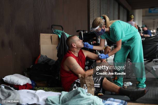 Dr. Natalia Echeverri, uses a swab to gather a sample from the nose of Juan Arias, who said he is homeless, to test for COVID-19 on April 17, 2020 in...