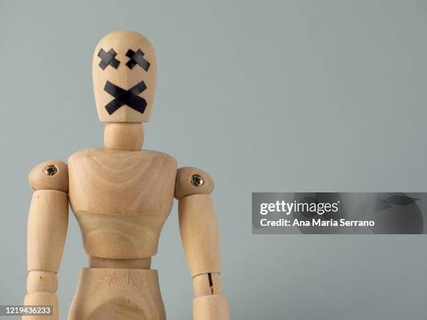 a wooden jointed doll with an x of duct tape covering its mouth and eyes - sect stockfoto's en -beelden