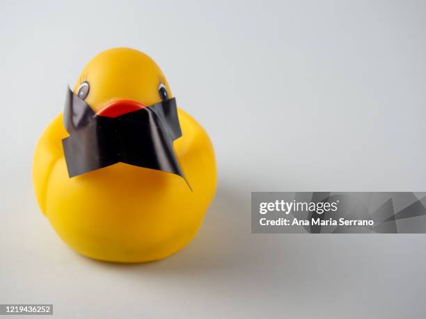 a rubber duck with an x of duct tape covering its mouth - political awkwardness stock-fotos und bilder