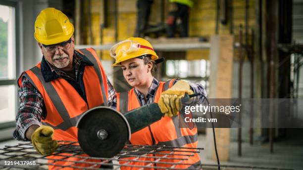 construction workers preparing to cut an iron mesh with an angle grinder - wire mesh construction stock pictures, royalty-free photos & images