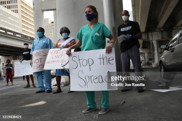 Volunteers, health care workers and doctors participate in a protest against what they say is the city's and county's poor response to helping the...