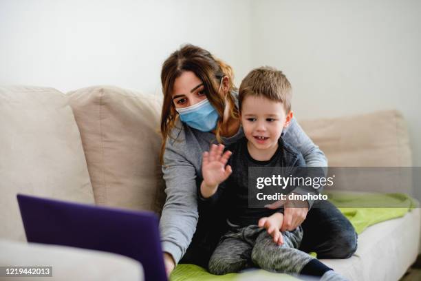 mother and son making video call with father during lockdown - human body part videos stock pictures, royalty-free photos & images