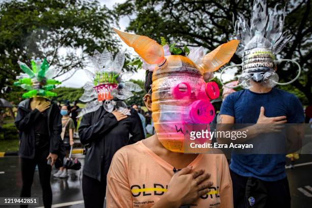 Filipinos wearing face masks made of recycled plastic bottles take part in a protest against President Duterte's Anti-Terror bill on June 12, 2020 in...