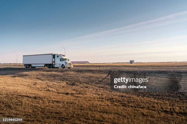 semi truck on the  rural trans-canada highway - saskatchewan highway stock pictures, royalty-free photos & images