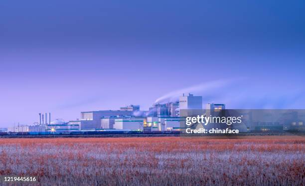 raffineriekomplex bei nacht - wind turbine long exposure stock-fotos und bilder