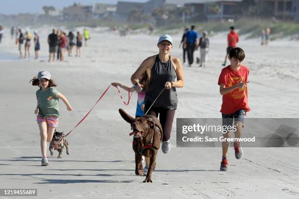 People run on the beach on April 17, 2020 in Jacksonville Beach, Florida. Jacksonville Mayor Lenny Curry announced Thursday that Duval County's...