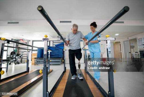 disabled senior man wearing a prosthetic and doing physical therapy - prosthetic stock pictures, royalty-free photos & images