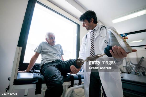 hombre discapacitado usando una prótesis y haciendo fisioterapia - amputado fotografías e imágenes de stock