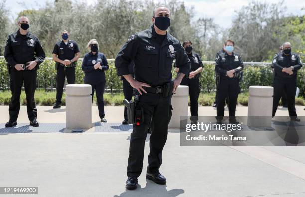 Los Angeles Police Department officers wear face masks as they wait to salute healthcare workers after fellow LAPD Detective Michael Chang was...