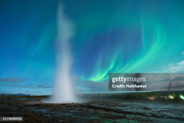 aurora borealis curving over strokkur geysir in iceland - geyser ストックフォトと画像