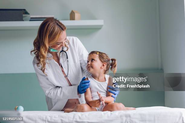 buon dottore e un piccolo paziente carino durante un controllo medico - pediatra foto e immagini stock