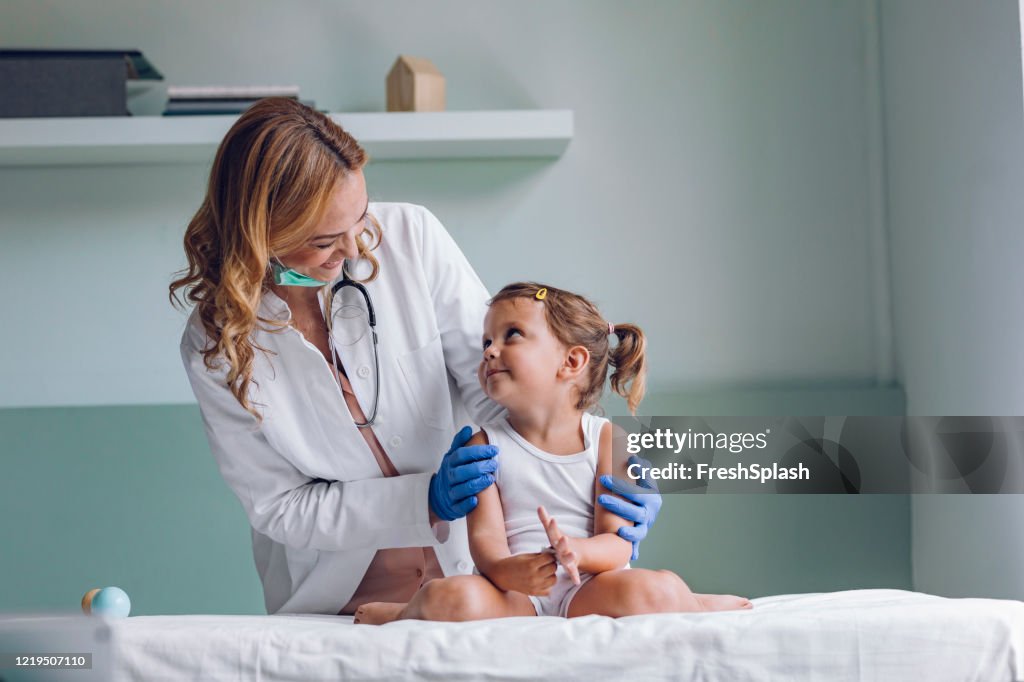 Médico feliz e um paciente fofo durante um check-up médico