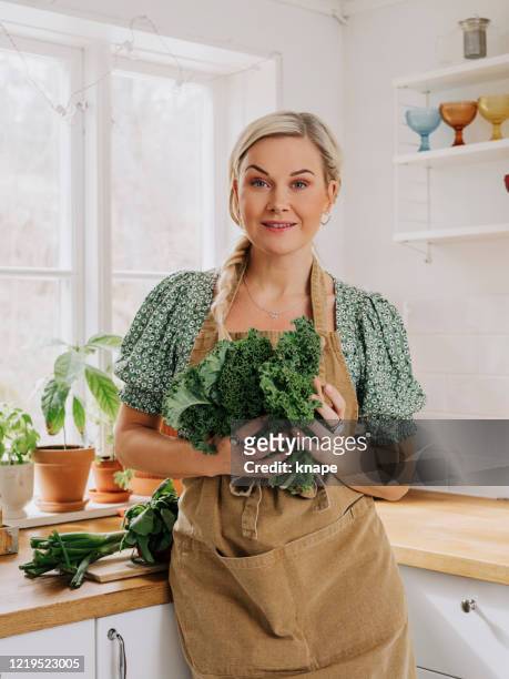 mujer en casa en la cocina con verduras kale - cabbage family fotografías e imágenes de stock
