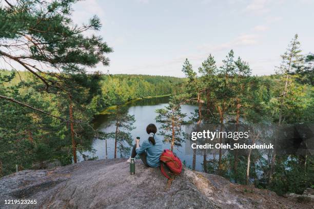 vrouw die meer in finland bekijkt en thee drinkt - hiking nature stockfoto's en -beelden