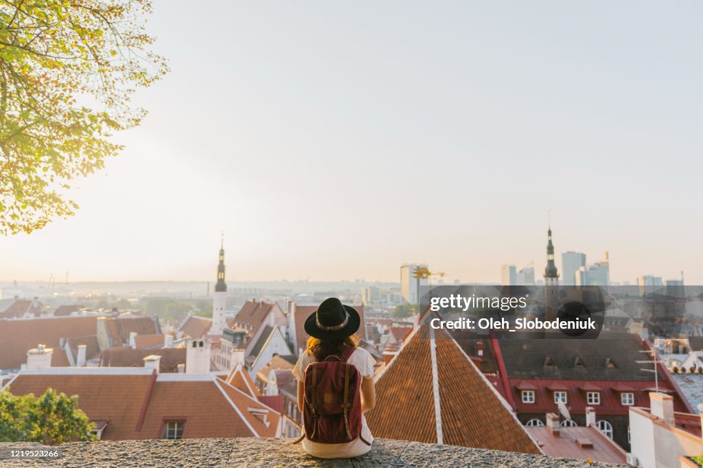 Woman sitting and looking at Tallinn in the morning