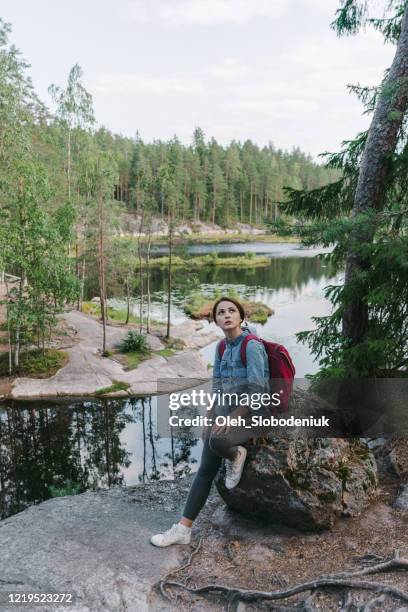 frau sitzt in der nähe des sees in finnland - finnish culture stock-fotos und bilder