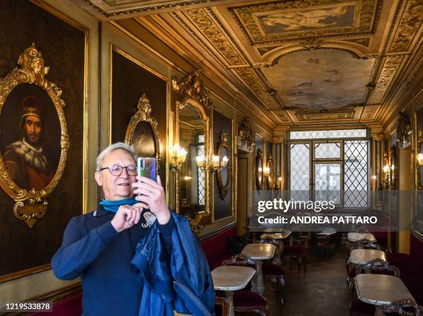 Customer takes a selfie photo on June 12, 2020 at the 18th Century Cafe Florian on St. Mark's Square in Venice, which reopens after being closed for...