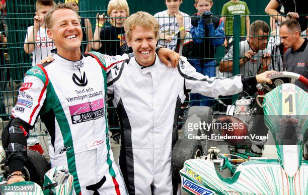 Michael Schumacher and Sebastian Vettel pose for the media during the 50th birthday of the Kart Club Kerpen on August 24, 2011 in Kerpen, Germany.