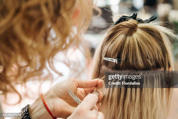 girl hairdresser doing hairstyle styling for a middle-aged woman in a beauty salon - inserindo - fotografias e filmes do acervo