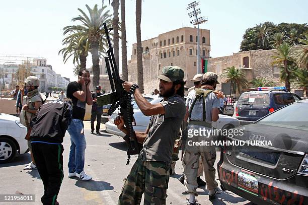 Libyan rebel fires celebratory shots in the air at the newly named Martyr's Square, formerly known as Green Square, in the capital Tripoli on August...