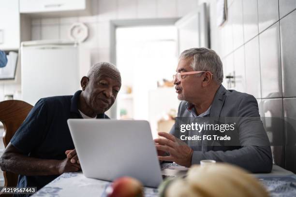 senior man having a consultation with a financial advisor at home - fiduciary responsibility stock pictures, royalty-free photos & images