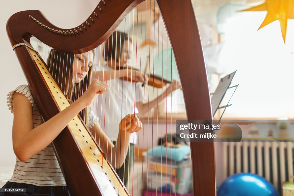Jongen en meisje die muziek thuis spelen