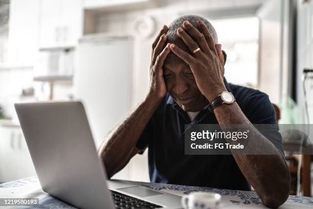 worried senior man working at laptop - technology frustration stock pictures, royalty-free photos & images