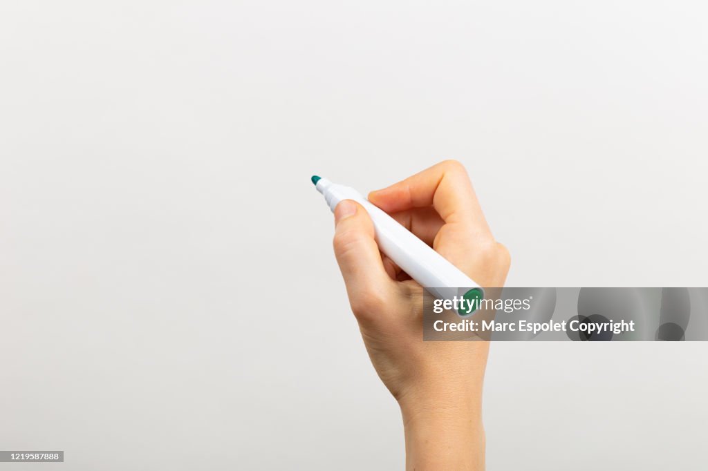 Hand writing with a green marker in a white board