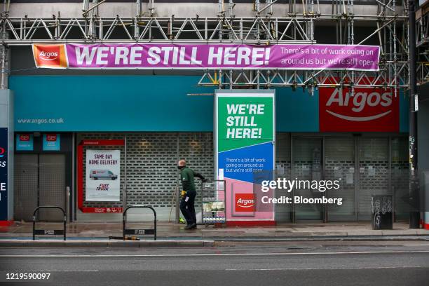 Courier pulls a crate of milk cartons past a shuttered Argos catalog shop, operated by J Sainsbury Plc, in London, U.K., on Friday, June 12, 2020....